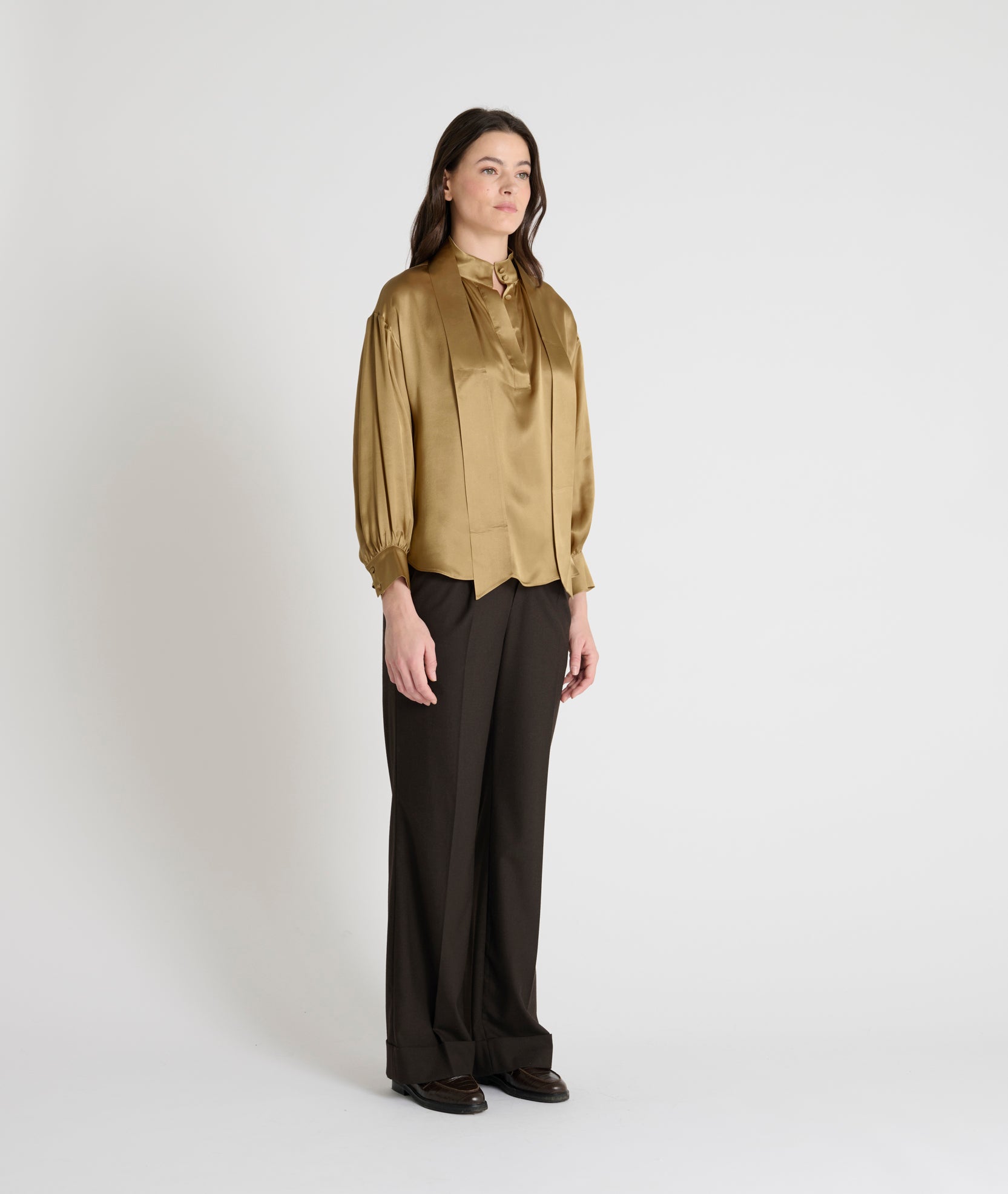 gold satin blouse with a tie bow at the neck and buttoned cuffs model shot