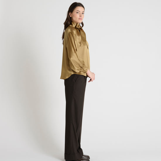 gold satin blouse with a tie bow at the neck and buttoned cuffs side view