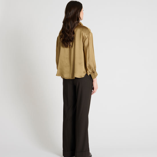 gold satin blouse with a tie bow at the neck and buttoned cuffs rear view