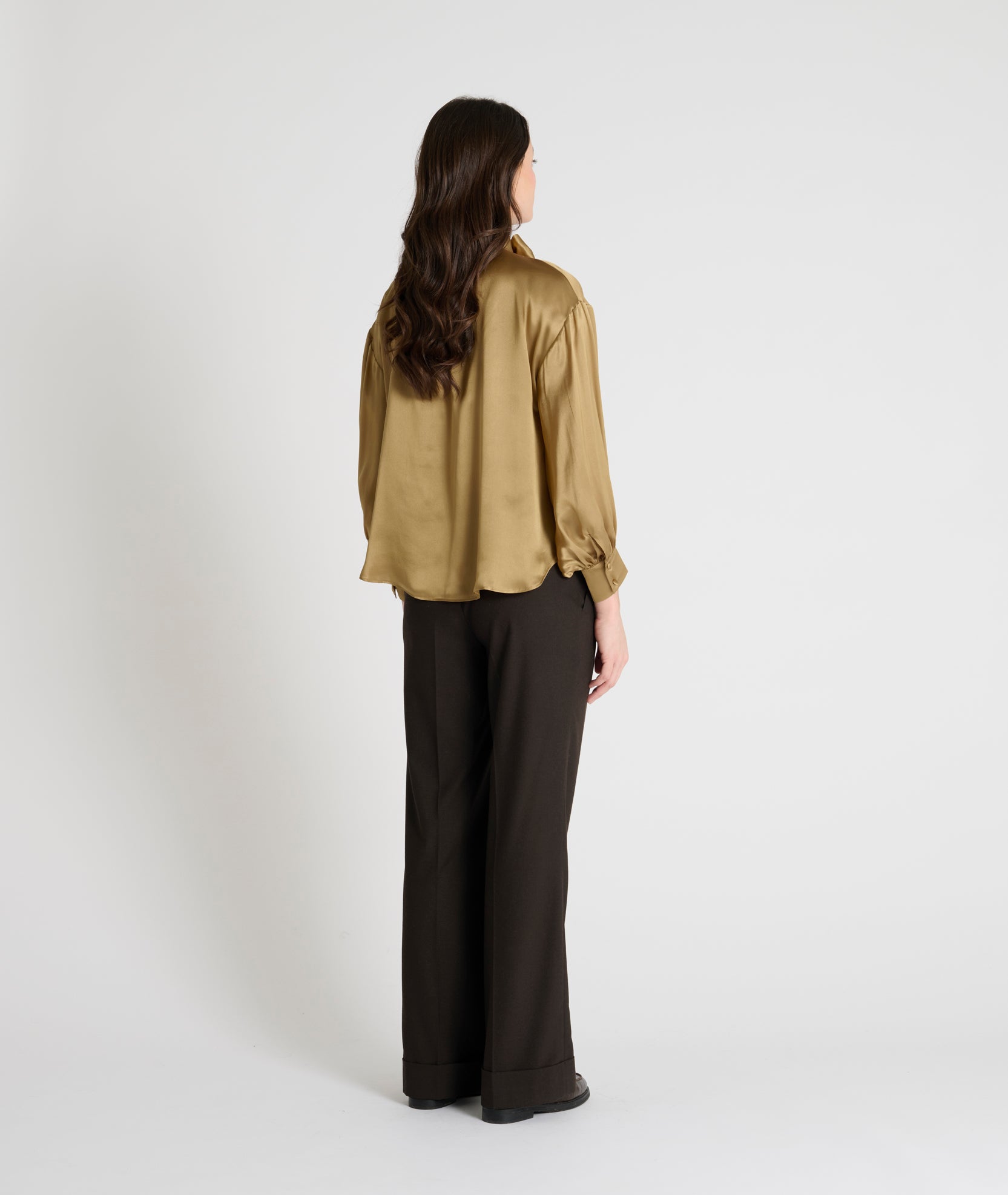 gold satin blouse with a tie bow at the neck and buttoned cuffs rear view