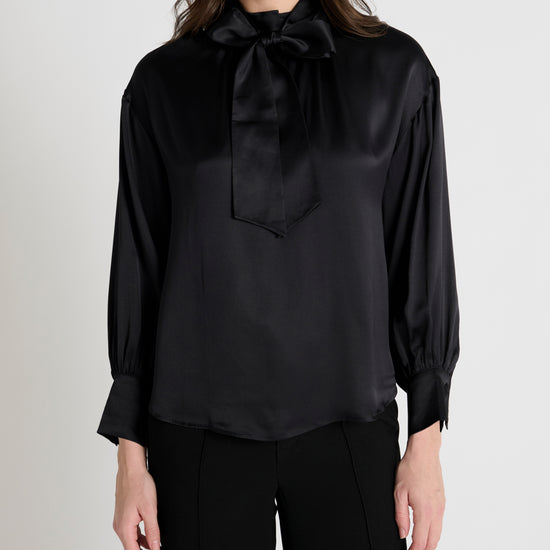 black satin blouse with a tie bow at the neck and buttoned cuffs