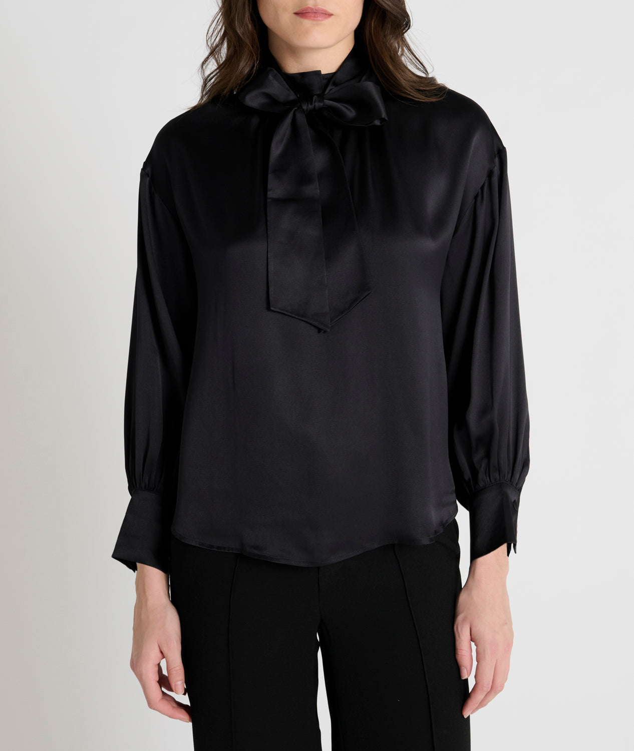 black satin blouse with a tie bow at the neck and buttoned cuffs