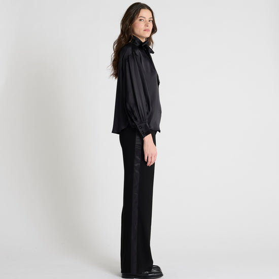 black satin blouse with a tie bow at the neck and buttoned cuffs side view