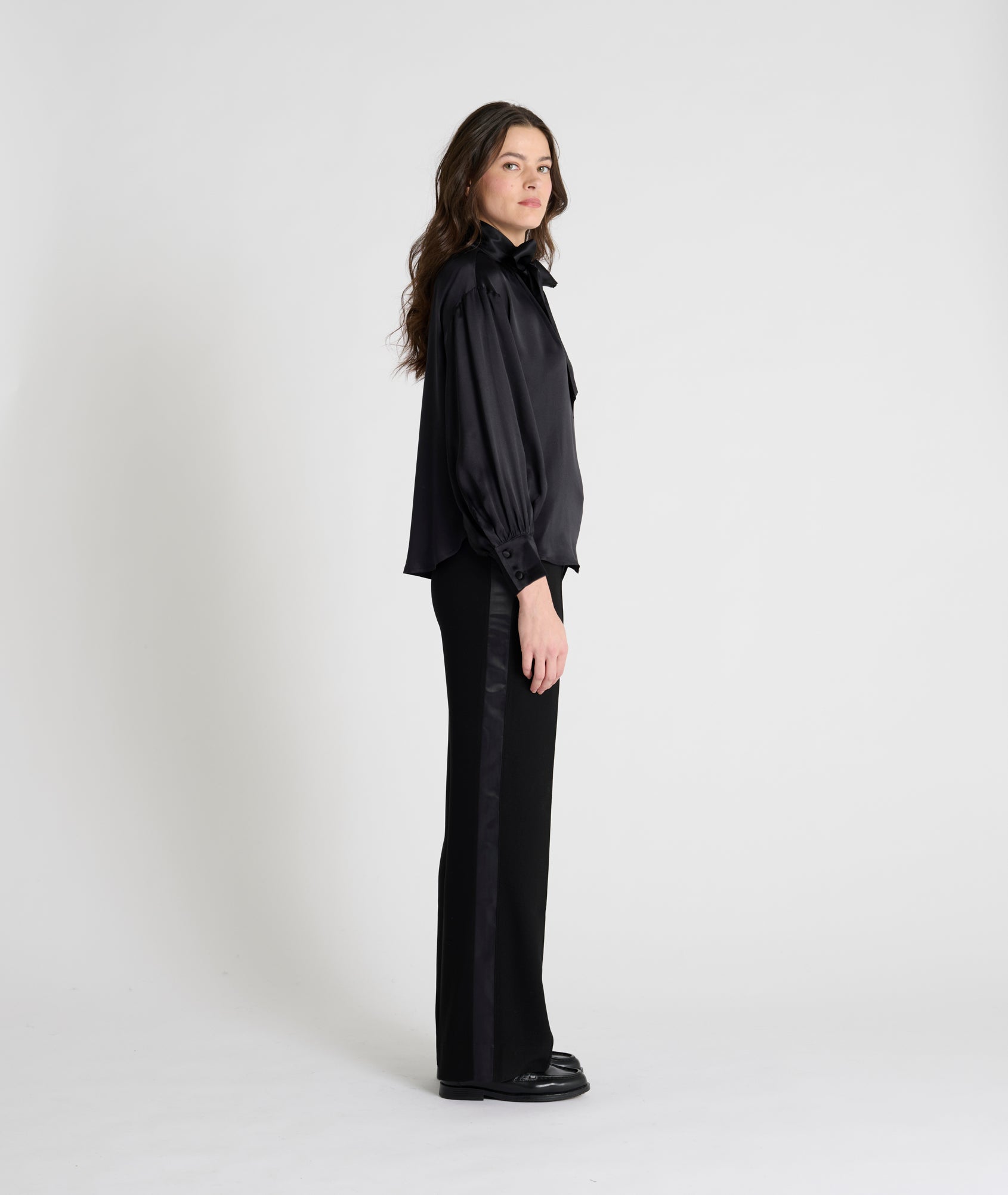 black satin blouse with a tie bow at the neck and buttoned cuffs side view