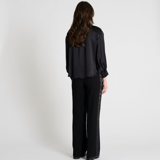 black satin blouse with a tie bow at the neck and buttoned cuffs rear view