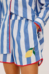 Blue and white striped outfit with a lemon design on a plain background