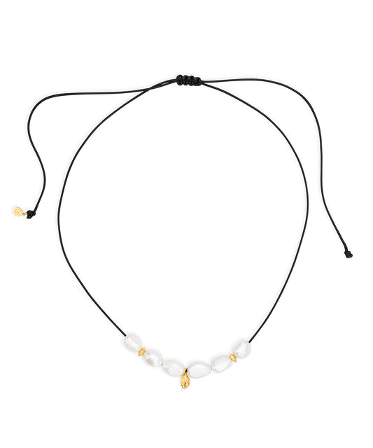Necklace with white pearl beads and gold accents on a black cord against a white background