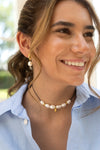 Woman wearing a pearl necklace and earrings outdoors