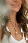 Woman wearing a pearl necklace with a blurred background