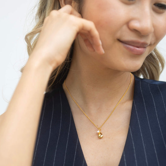 gold necklace with pendant and pearl model shot