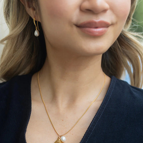model shot of pearl drop earrings and pendant necklace from Claudia Bradby