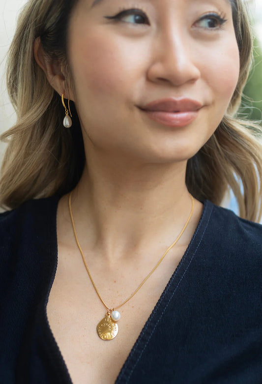 model shot of pearl drop earrings and pendant necklace from Claudia Bradby