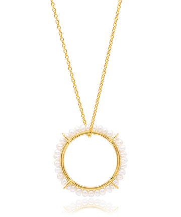 Gold necklace with a circular pendant featuring small pearls on a white background
