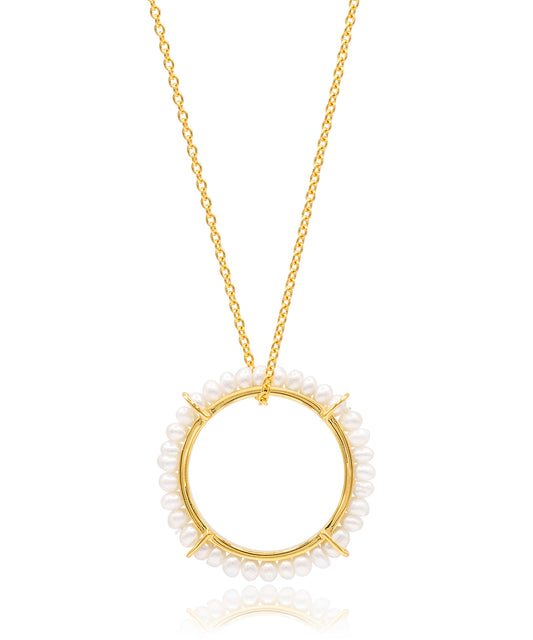 Gold necklace with a circular pendant featuring small pearls on a white background