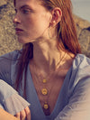 Woman wearing gold necklaces and earrings outdoors