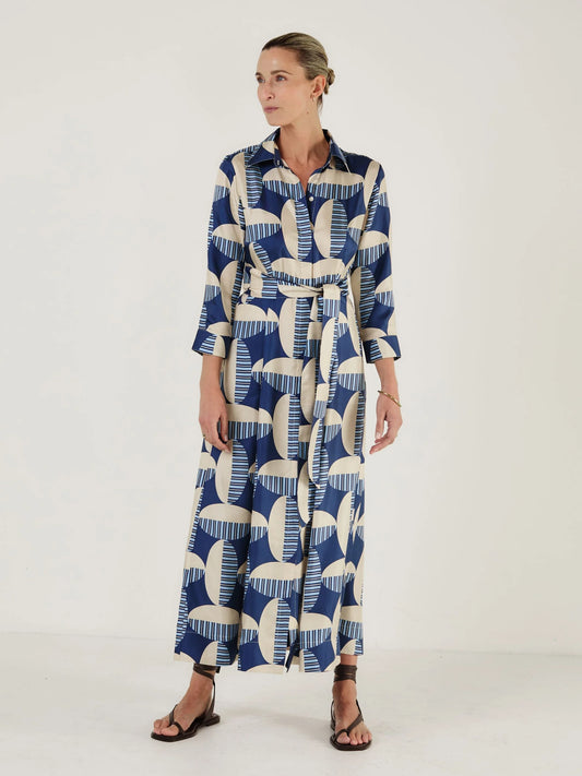 Woman wearing a blue and white patterned dress from Mondo Corsini on a white background