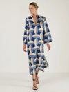 Woman wearing a blue and white patterned kaftan dress from Mondo Corsini on a white background