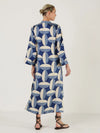 Woman wearing a blue and white patterned kaftan dress from Mondo Corsini on a white background. Rear view