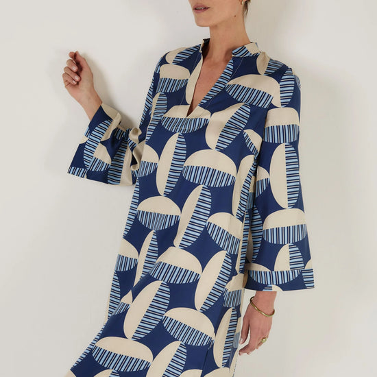 Woman wearing a blue and white patterned kaftan dress from Mondo Corsini on a white background. Close up