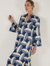 Woman wearing a blue and white patterned kaftan dress from Mondo Corsini on a white background. Close up