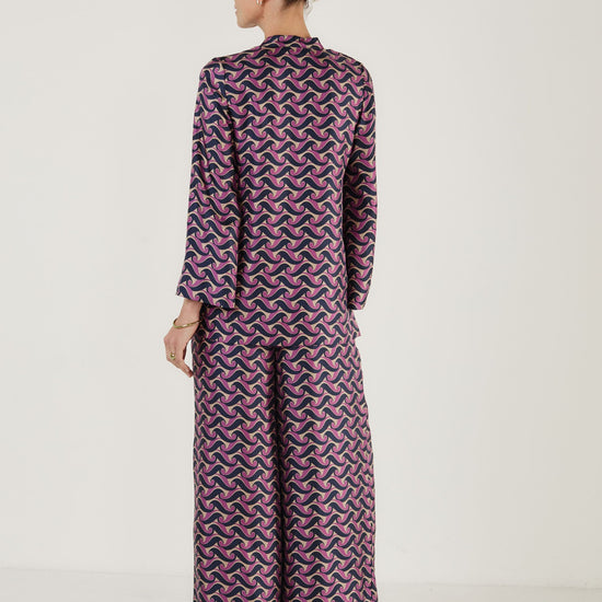 Rear view of printed silk top worn with matching wide leg trousers from Mondo Corsini