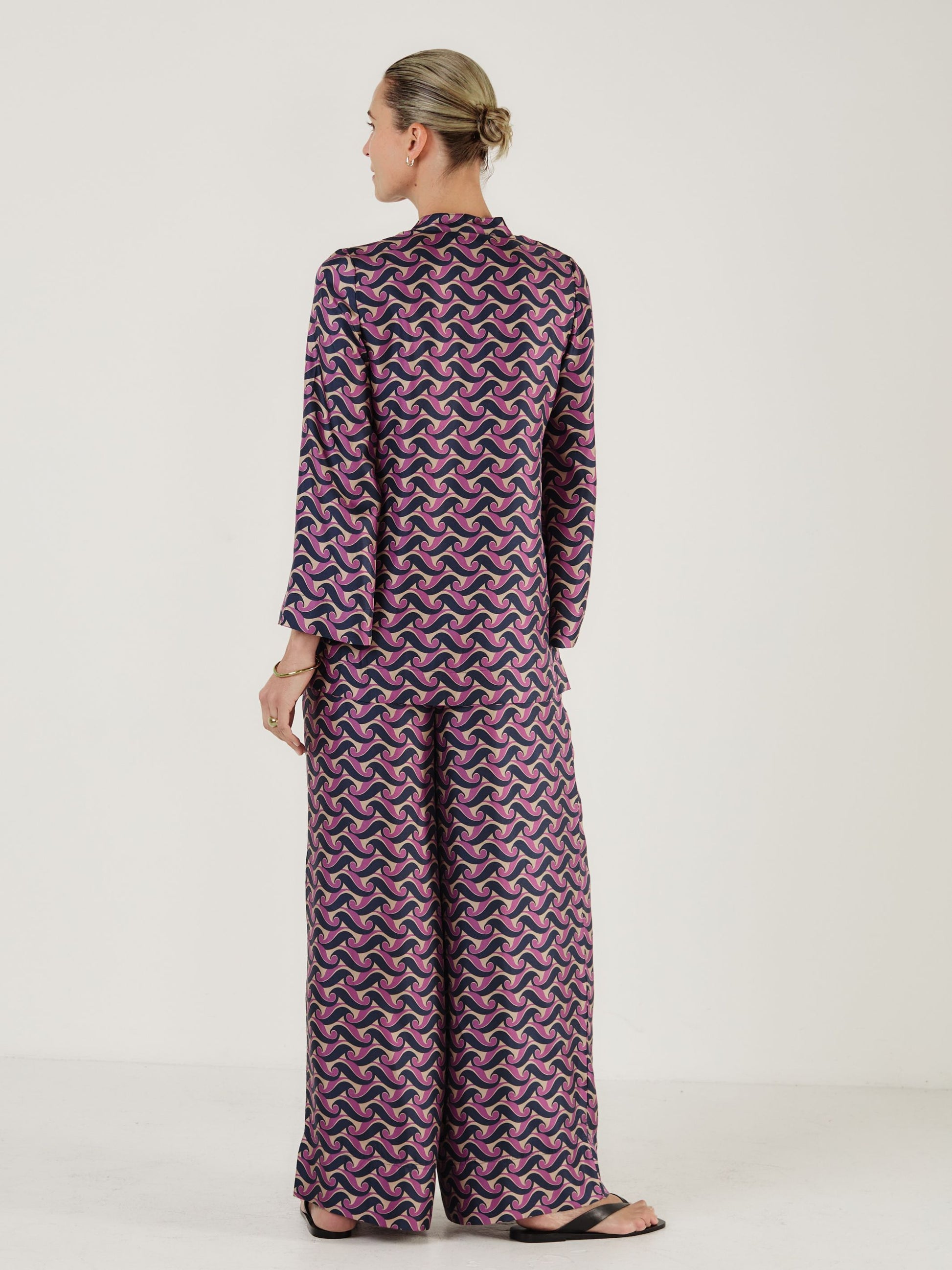 Rear view of printed silk top worn with matching wide leg trousers from Mondo Corsini