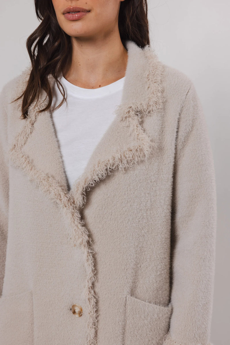 knitted long cardigan with frayed edge and 2 front pockets  close up