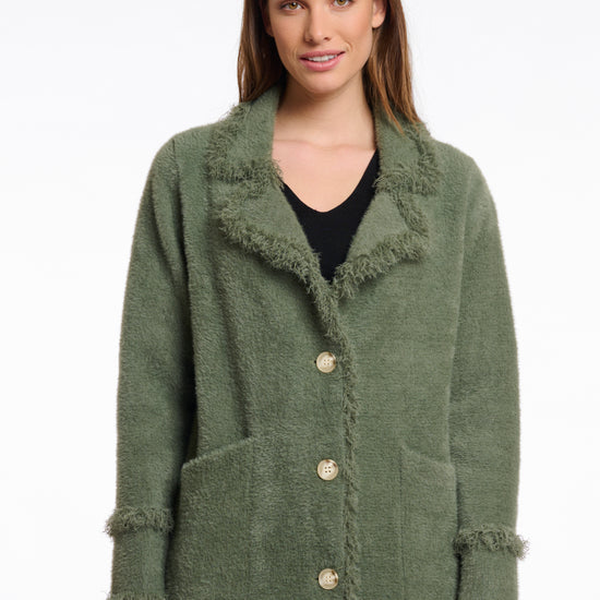 green fluffy long cardigan which comes just above the knee with fringe detailing patch pockets and long sleeves close up