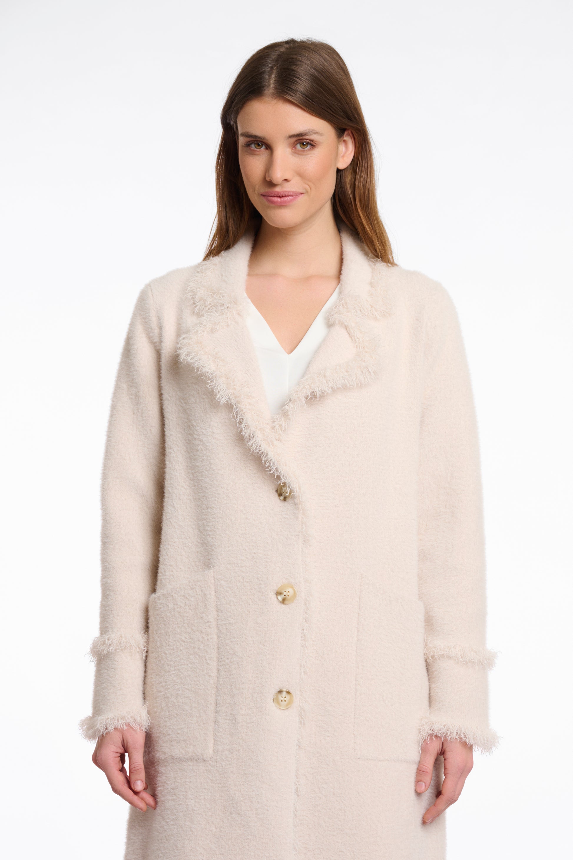 pale pink fluffy long cardigan which comes just above the knee with fringe detailing patch pockets and long sleeves close up