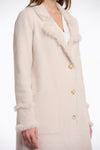 pale pink fluffy long cardigan which comes just above the knee with fringe detailing patch pockets and long sleeves side view