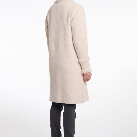 pale pink fluffy long cardigan which comes just above the knee with fringe detailing patch pockets and long sleeves rear view
