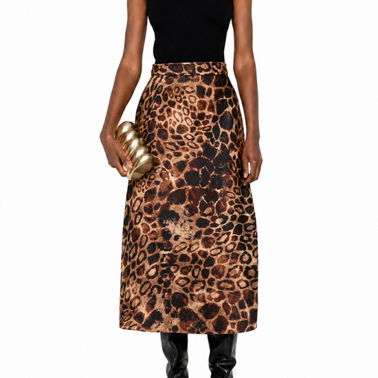 A model wearing a sleeveless black mock-neck top and a high-waisted leopard-print midi skirt, holding a gold metallic clutch, set against a plain white background.