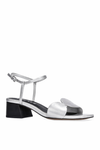 Silver sandal with a black block heel on a white background