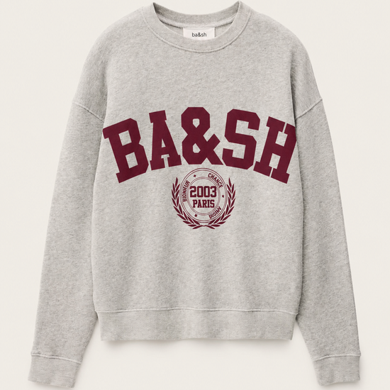 A light gray heather crewneck sweatshirt featuring a maroon'BA&SH' graphic and a circular crest on the front, displayed against a light off-white background.