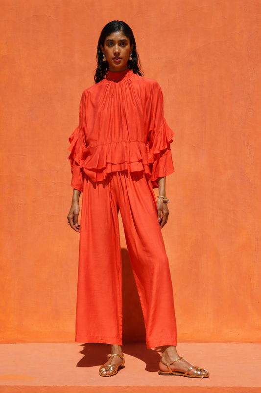 Woman wearing an orange outfit against an orange background