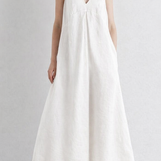 Woman wearing a white sleeveless dress on a plain background