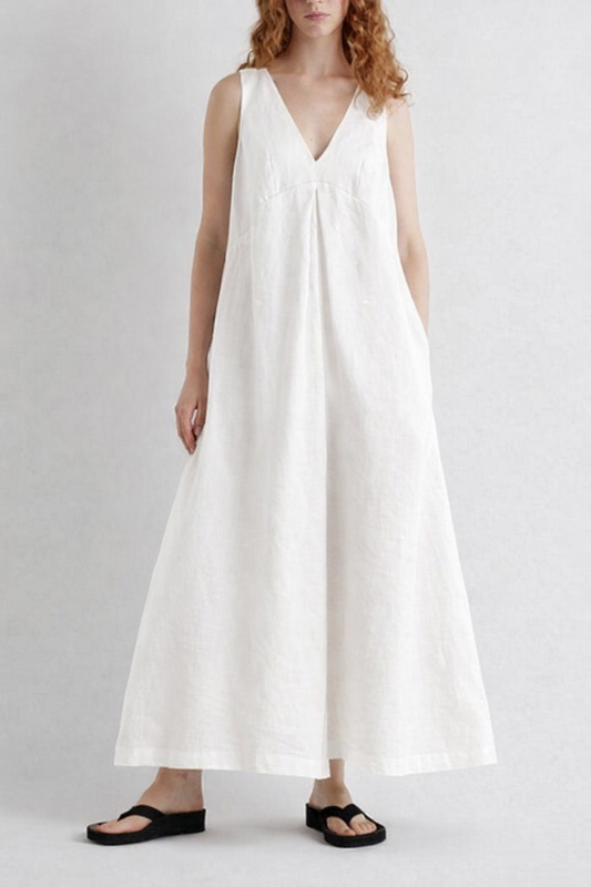 Woman wearing a white sleeveless dress on a plain background