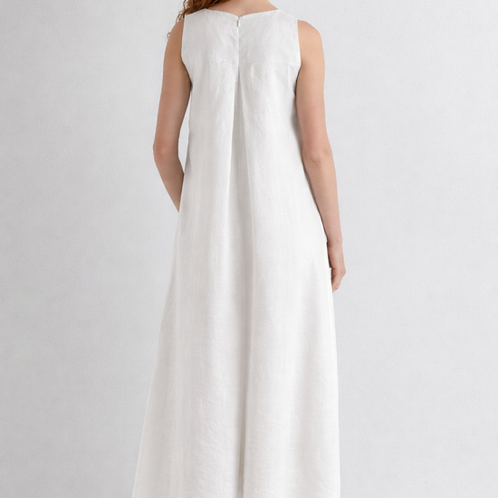Woman wearing a white sleeveless dress on a plain background