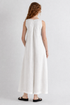 Woman wearing a white sleeveless dress on a plain background