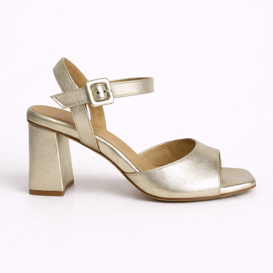 Gold high-heeled sandal on a white background