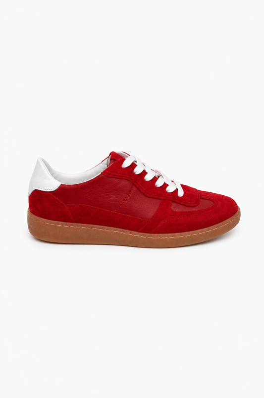 Close-up of a red suede trainer on a white background