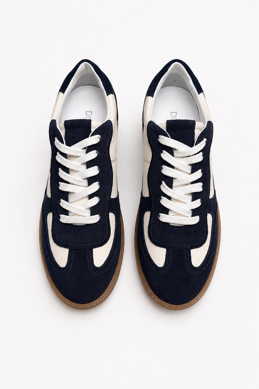 Navy blue sneakers with white laces on a white background