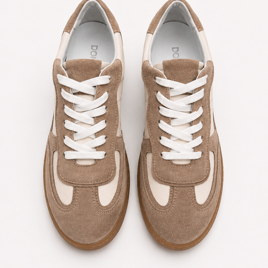 Pair of brown sneakers with white laces on a light gray background