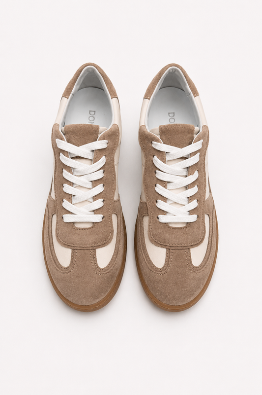 Pair of brown sneakers with white laces on a light gray background