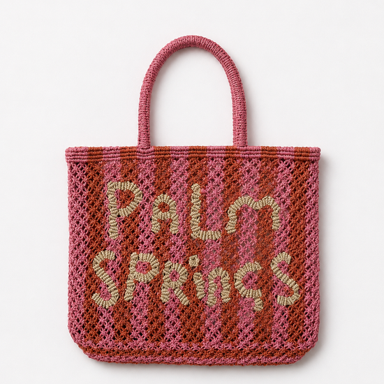 Pink and orange woven bag with 'Palm Springs' text on a white background