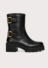 A black leather mid-calf boot with two gold-tone buckle straps and a chunky lug sole, shown against a plain light background.