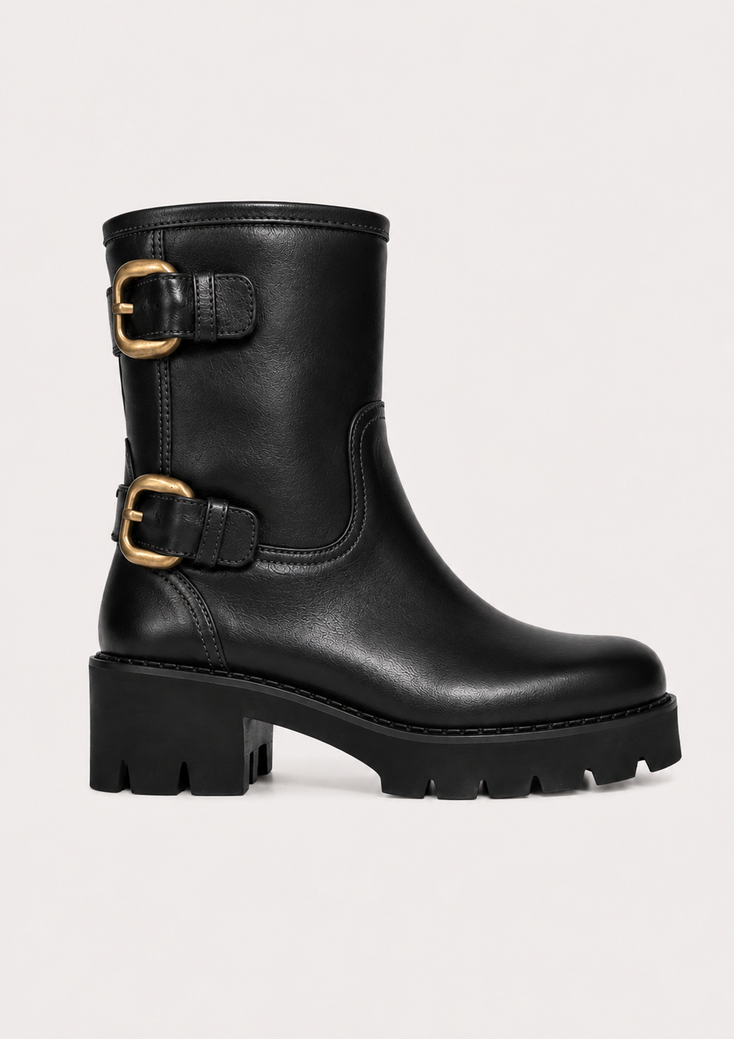 A black leather mid-calf boot with two gold-tone buckle straps and a chunky lug sole, shown against a plain light background.