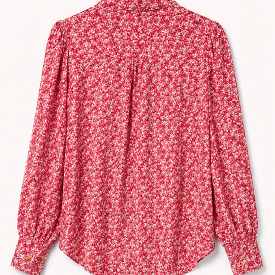 Product shot of the back of a pink floral shirt.
