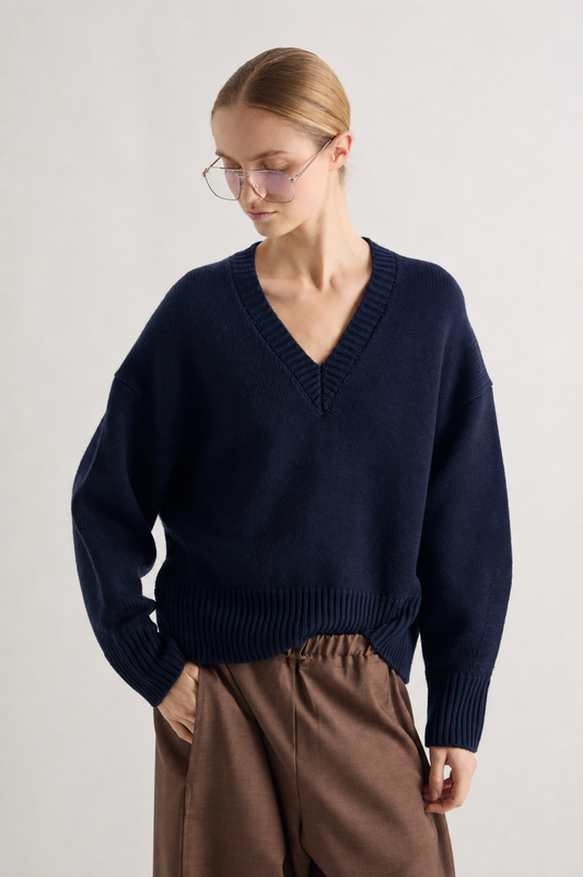 Chunky V neck jumper in navy worn with brown trousers