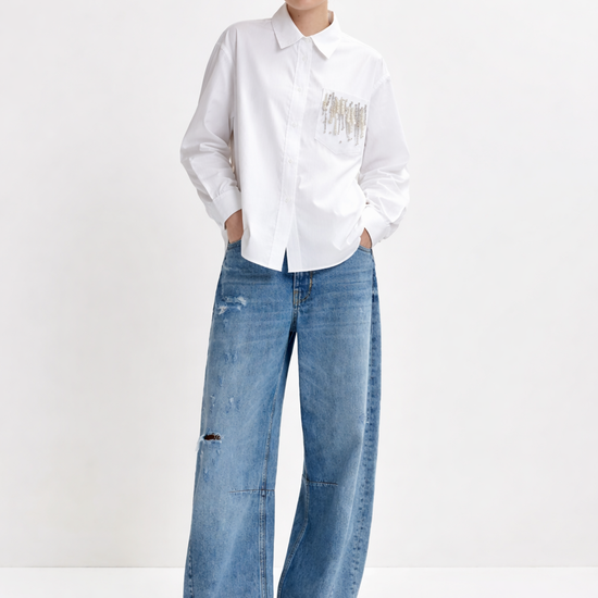 Person wearing a white shirt with text and blue jeans on a white background